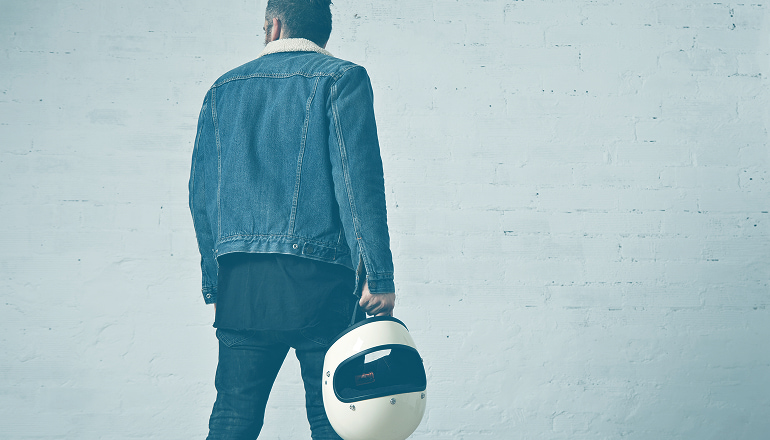 hombre con un casco en la mano sin saber el impacto en la indemnizacion por accidente de tráfico que tiene el casco
